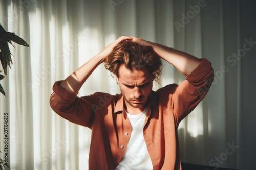 unpleasant pain. sad unhappy handsome man sitting on the sofa and holding his forehead while having headache