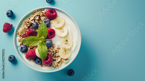 Healthy breakfast with muesli, yogurt and fresh berries on blue background top view with copy space