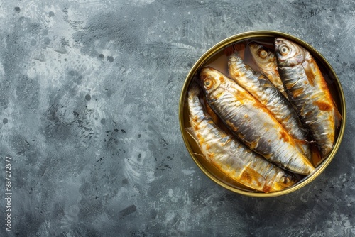 Close up and top view of smoked canned sardine in a tin over gray background, space for text. Tinned fish as a convenient, fast, healthy food and source of omega-3 fatty acids, protein and vitamin D