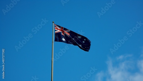 Flag of Australia waving in the wind. Blue sky background.