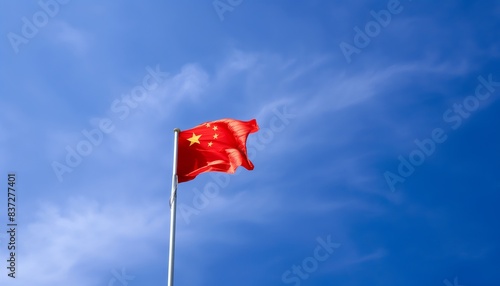 Flag of China waving in the wind. Blue sky background.