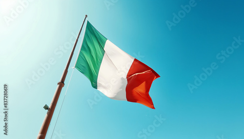 Flag of Italy waving in the wind. Blue sky background.