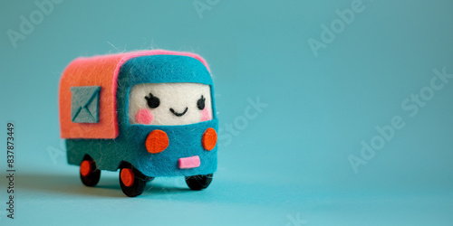 Felt toy mail van with envelope icon on the side and a happy Kawaii smiling face. A plushie delivery vehicle on a background with copy space