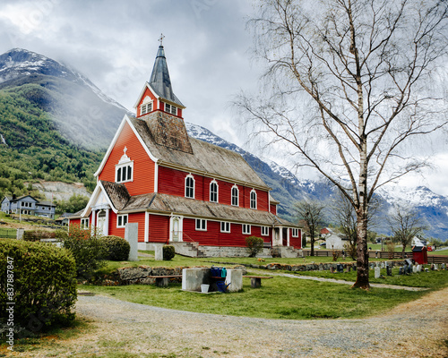 Czerwony drewniany kościół na tle norweskiego krajobrazu, Norwegia