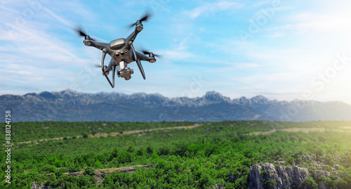 A drone with a camera flies against the backdrop of a mountain landscape.