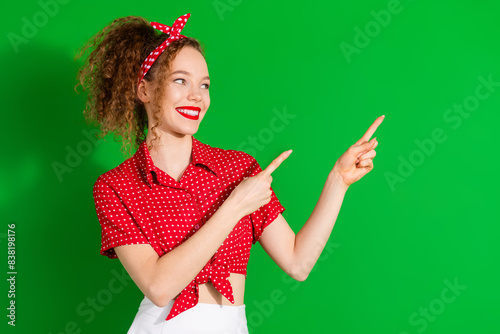 Photo portrait of lovely young lady look point empty space dressed stylish red retro garment isolated on green color background
