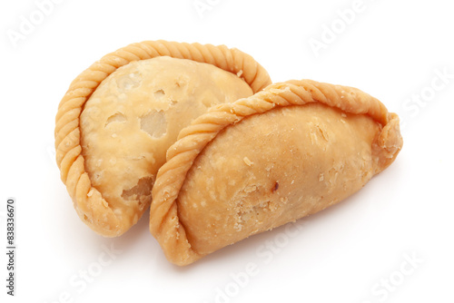 Indian Traditional sweet dry "Gujiya", made for the Indian festival of colors "Holi". The sweet is made of maida (flour), and ghee, filled with Mawa and Dry fruits, Front view, isolated on white.