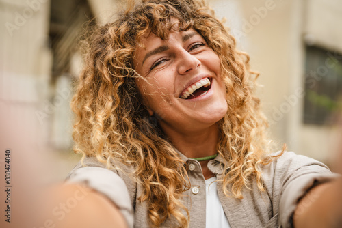 Adult woman hold mobile phone and take picture of herself self portrait