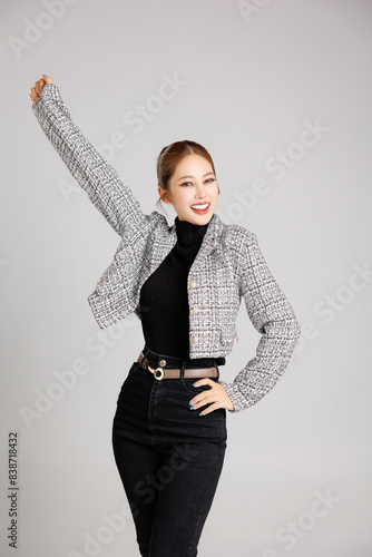 Asian smart happy entrepreneur business woman smile in casual suit gesture aised hands celebrating success and looking at camera on isolated grey background. Use for advertising