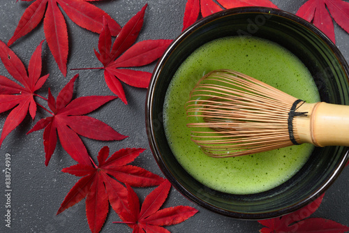 日本の茶道 茶碗と茶筅と抹茶と赤いもみじ 黒背景 Japanese Tea ceremony: Tea bowl, tea whisk, matcha and red maple leaves on black background 