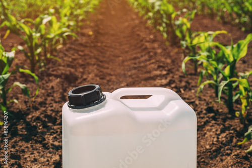 Closeup of herbicide container in corn maize crop field