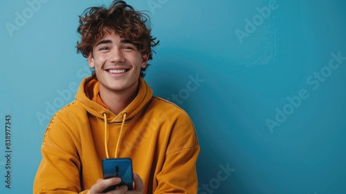 Cheerful Young Man with Smartphone Against Blue Background