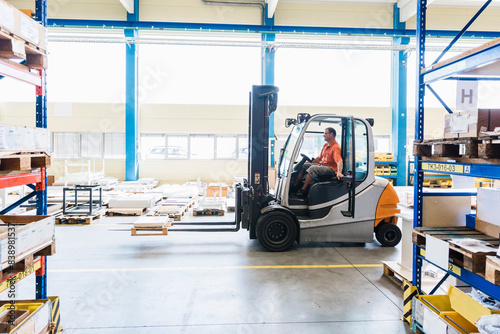 Man on forklift in factory warehouse