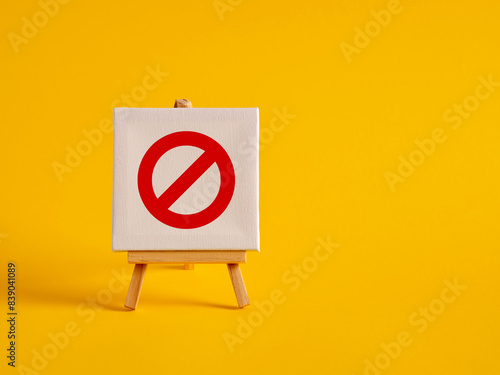 A canvas with no entry sign on an easel with yellow background with copy space.