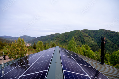 Rooftop with solar panels on house in mountains. Energy independence and sustainability concept