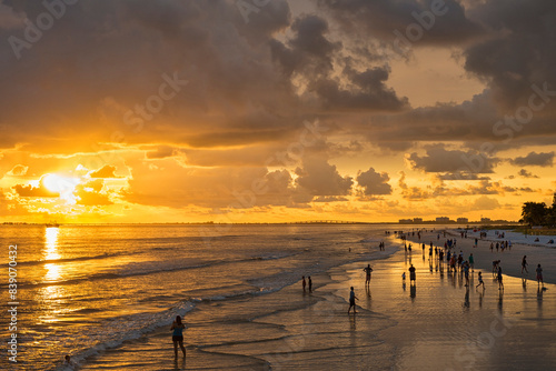 USA, Florida, Fort Myers, silhouettes of Fort Myers Beach and tourists with a huge rain cloud above during sunset