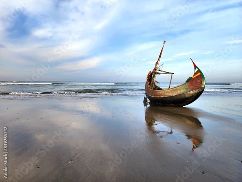 Boat moored on the shore with a serene ocean in the background. Cox's Bazar, Bangladesh