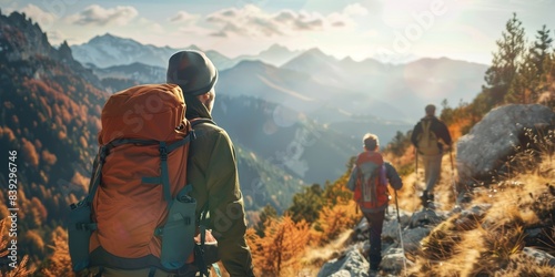 The image shows a group of hikers on a mountain trail. The hikers are wearing backpacks and hiking gear and are surrounded by mountains.