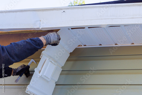 A house master makes repairs to damaged fascia trim during remodeling at home