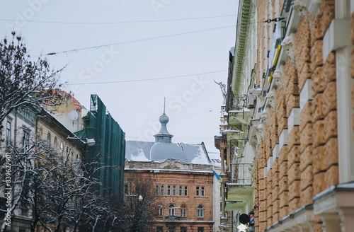 Roofs and facades of old buildings with scaffolding in the center of Lviv, Ukraine. Snowy winter.