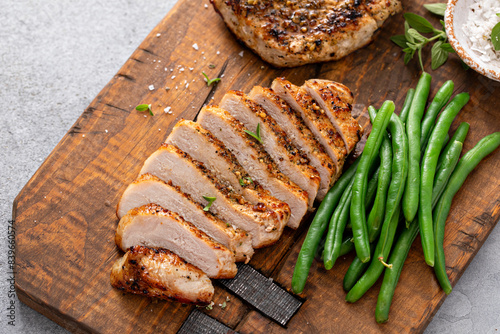 Grilled pork chop or chicken breast sliced on a cutting board