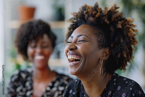 Two smiling women, one with afro hair and one with short hair