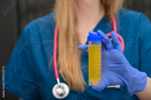 Kobieta naukowiec, laboratorium bada próbki mętnego moczu od pacjenta 