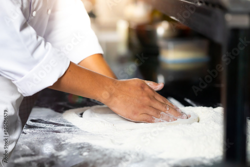 experienced chef - Professional chef prepares the dough with flour to make pizza or pasta Italian food