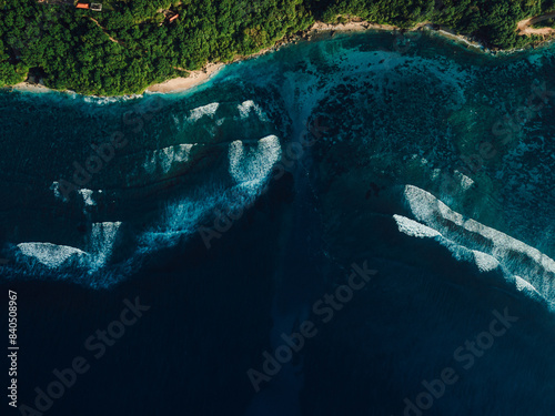 Aerial view of coastline with ocean waves and current canal in Bali. Green bowl beach