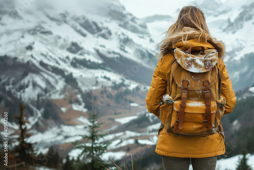 Eine Frau wandert in den Bergen. Sie steht an einem Aussichtspunkt und schaut auf die leicht verschneite Landschaft. KI generiert