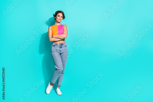 Full length photo of confident charming woman wear pink orange top arms folded empty space isolated teal color background