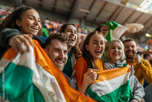 Ecstatic group of friends cheering, with one holding an Irish flag, at a sports match in a stadium setting
