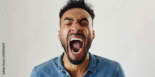 Angry man shouting on a white background expressing frustration and anger with his mouth wide open