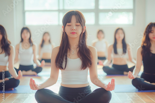 Attractive young Asian woman group exercising and sitting in yoga lotus position in yoga classes Breath control