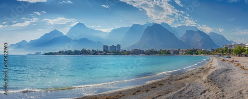 Aerial photograph of the Mediterranean landscape with a long, golden beach and resting people. Photo taken in Antalya, Turkey.