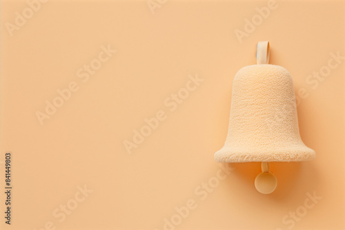 A stylish beige plushie notification bell icon with copy space. Simple, minimalist fabric reminder or digital alert symbol.