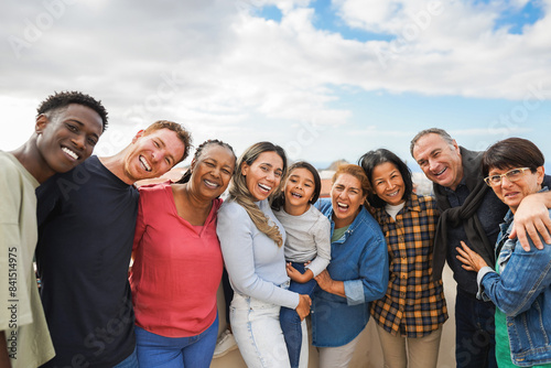 Group of multigenerational friends smiling in front of camera - Multiracial people of different ages having fun together - Main focus on african woman face