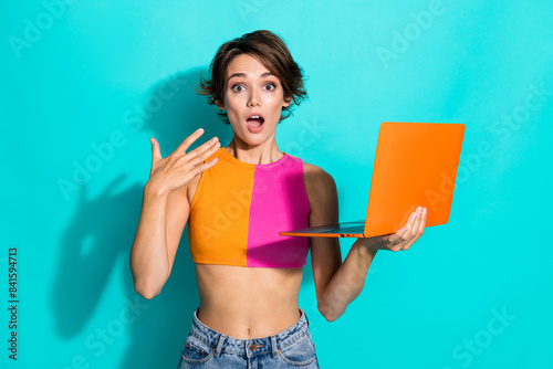 Photo of sweet shocked woman wear pink orange top getting message modern gadget isolated teal color background