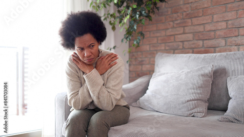 African American woman sitting at home, feeling miserable and depressed