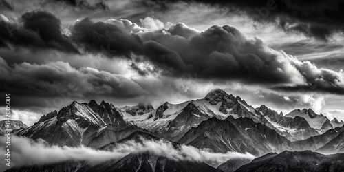 A dramatic black and white photograph capturing a stark silhouette of a mountain range against a smoky, ominous sky