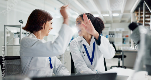 Women, high five and laptop in lab for science, notification or celebration for research project. People, scientist and lab partner by computer for cheers, excited or results for funding application