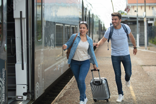 young couple with suitcase late for train