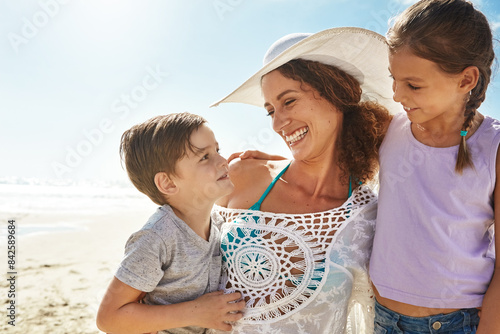 Beach, family and woman smile for holiday, fun and together with children for Australia adventure. Summer, ocean and vacation afternoon with happy mother, siblings and kids laughing in nature