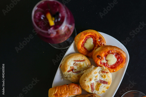 Cocktail alcolici e analcolici serviti con pizzette e prodotti da forno in un bar elegante per aperitivo