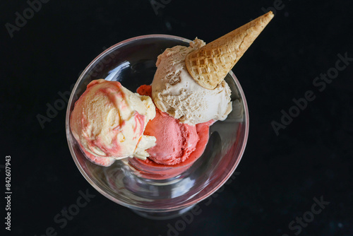 Coppa di vetro elegante servita in un bar con del gelato alla frutta guarnito con una cono croccante