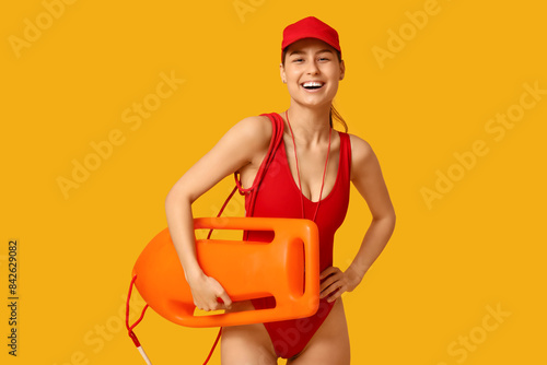 Female lifeguard with rescue tube buoy on yellow background