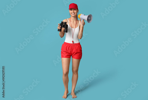 Female lifeguard with megaphone and binoculars on blue background
