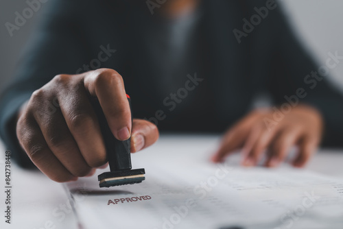 Close-up Of A Person's Hand Stamping With Approved Stamp On Text Approved Document At Desk, Contract Form Paper