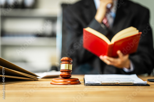 A young businesswoman is working at her desk, diligently preparing legal briefs and reviewing evidence for an upcoming trial, demonstrating her expertise as a lawyer in litigation and advocacy.