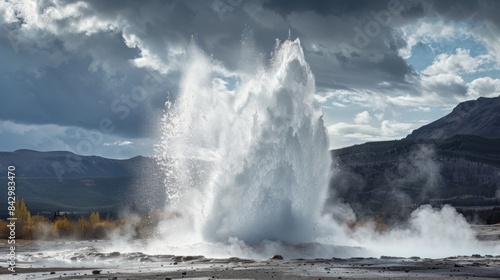 A geyser erupting with force sending water and steam into the air.